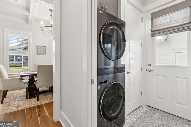 105 Whispering Oaks Ln, Saint Marys, GA 31558 - laundry room featuring baseboards, a chandelier, crown molding, stacked washer / drying machine, and light wood finished floors