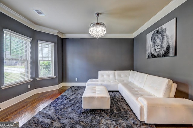 living area with a chandelier, crown molding, wood finished floors, and visible vents