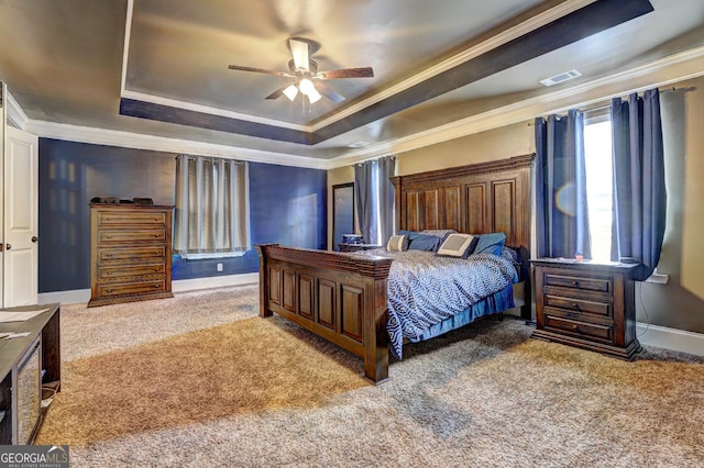 carpeted bedroom featuring ceiling fan, ornamental molding, visible vents, a raised ceiling, and baseboards