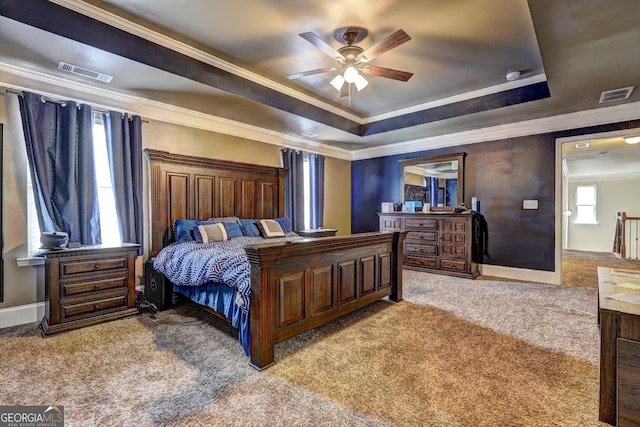 bedroom featuring a raised ceiling, ornamental molding, carpet, and visible vents