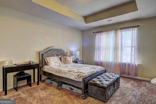 bedroom featuring a raised ceiling, carpet flooring, baseboards, and visible vents