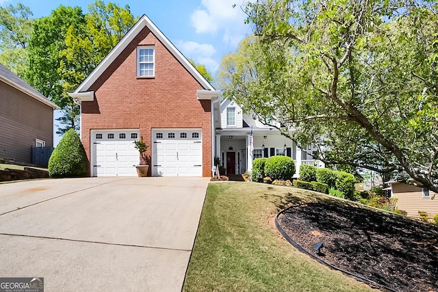 view of front of house featuring a garage, concrete driveway, a front lawn, and brick siding