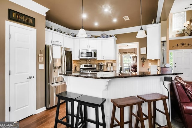 561 Valleyside Dr, Dallas, GA 30157 - kitchen featuring appliances with stainless steel finishes, decorative backsplash, a peninsula, white cabinets, and dark wood-type flooring