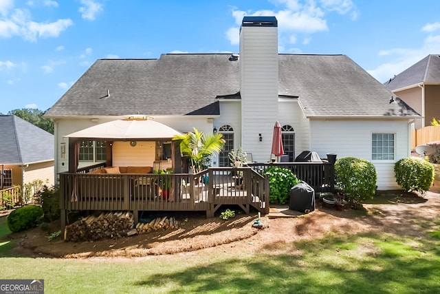 back of house with a chimney, a shingled roof, an outdoor hangout area, and a deck