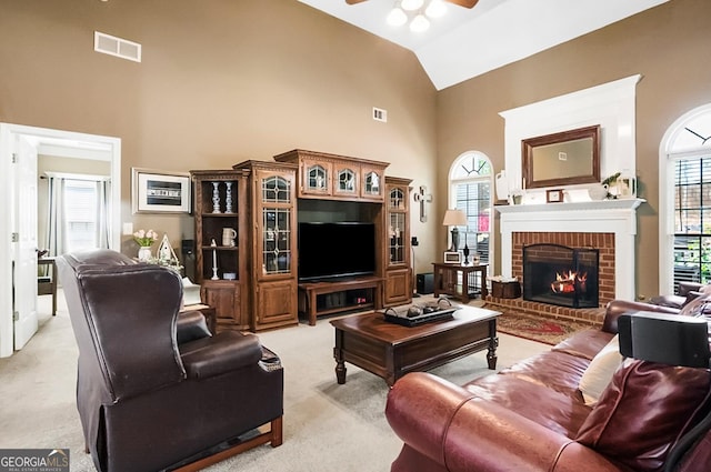 living room featuring high vaulted ceiling, a ceiling fan, light colored carpet, and visible vents