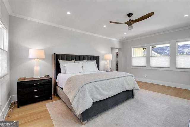 bedroom with light wood-type flooring, ceiling fan, baseboards, and ornamental molding