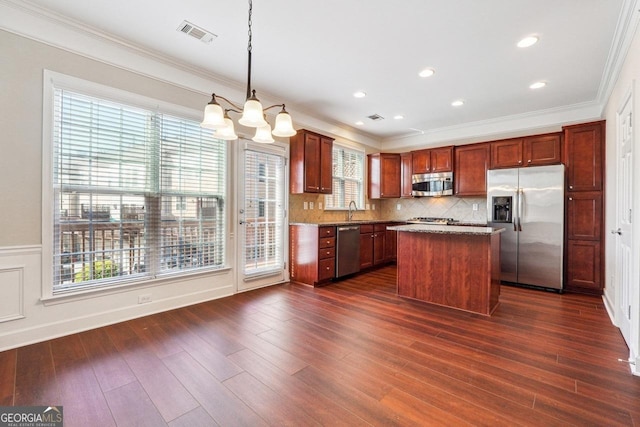 kitchen featuring visible vents, a center island, stainless steel appliances, decorative backsplash, and a notable chandelier