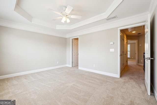 unfurnished bedroom with light colored carpet, attic access, ornamental molding, and visible vents