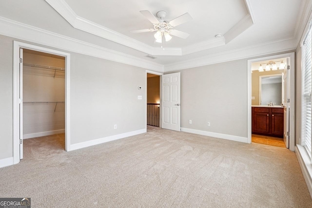 unfurnished bedroom with light carpet, a tray ceiling, and ornamental molding