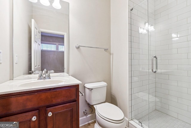 bathroom with a shower stall, vanity, and toilet