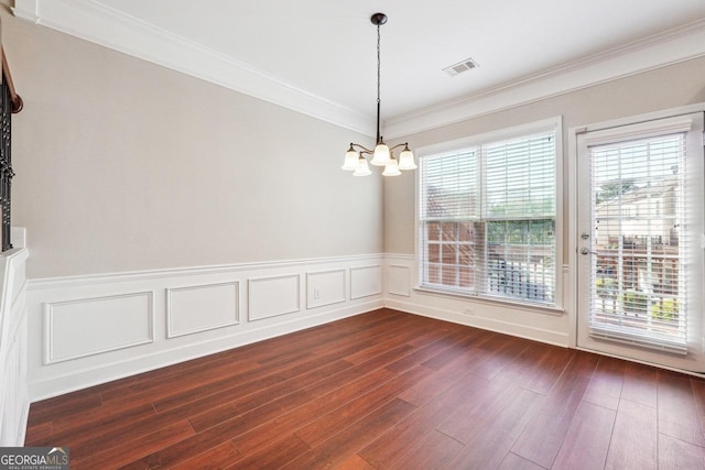 unfurnished dining area with an inviting chandelier, ornamental molding, visible vents, and dark wood-style flooring
