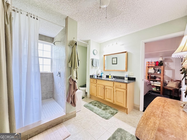 80 Hill Farm Rd, Alamo, GA 30411 - bathroom featuring vanity, tiled shower, tile patterned flooring, toilet, and a textured ceiling