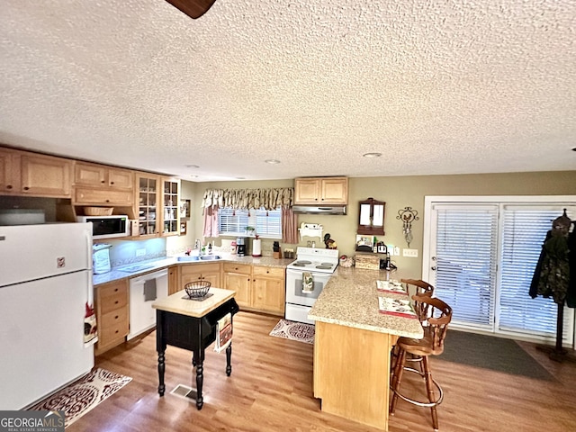 80 Hill Farm Rd, Alamo, GA 30411 - kitchen with white appliances, a peninsula, a textured ceiling, light brown cabinets, and light wood finished floors