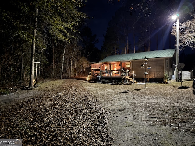 80 Hill Farm Rd, Alamo, GA 30411 - back of house at twilight featuring metal roof and a wooden deck