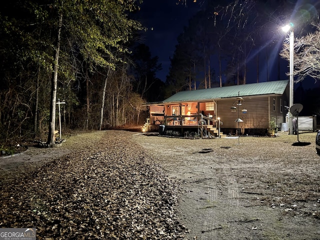 80 Hill Farm Rd, Alamo, GA 30411 - back of house at twilight featuring metal roof and a wooden deck
