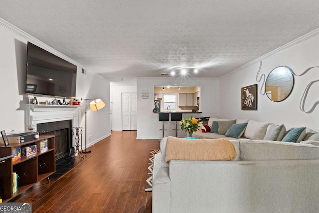 113 Brittany Ct, Duluth, GA 30096 - living room with dark wood-type flooring, a textured ceiling, a fireplace with flush hearth, ornamental molding, and baseboards