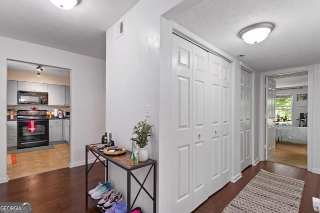 113 Brittany Ct, Duluth, GA 30096 - hallway with visible vents, baseboards, wood finished floors, and a textured ceiling