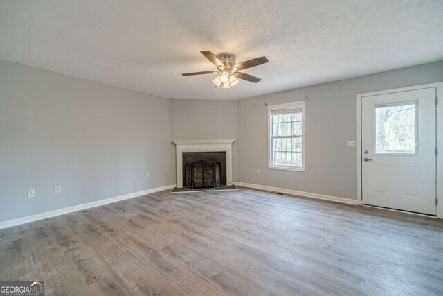 29 Monte Ln, Jefferson, GA 30549 - unfurnished living room with ceiling fan, wood finished floors, a fireplace, and a textured ceiling
