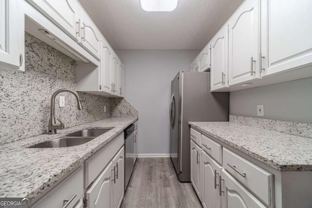29 Monte Ln, Jefferson, GA 30549 - kitchen with appliances with stainless steel finishes, white cabinetry, light wood finished floors, backsplash, and light stone countertops
