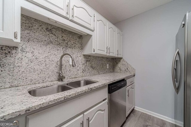 29 Monte Ln, Jefferson, GA 30549 - kitchen featuring stainless steel appliances, wood finished floors, tasteful backsplash, white cabinetry, and light stone countertops