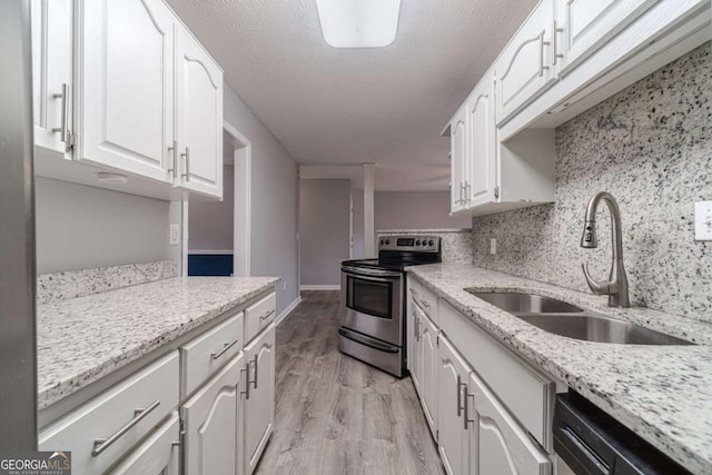 29 Monte Ln, Jefferson, GA 30549 - kitchen featuring appliances with stainless steel finishes, white cabinets, light wood-style floors, light stone counters, and backsplash