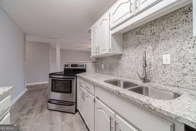 29 Monte Ln, Jefferson, GA 30549 - kitchen with stainless steel electric stove, white cabinetry, backsplash, light stone counters, and light wood finished floors