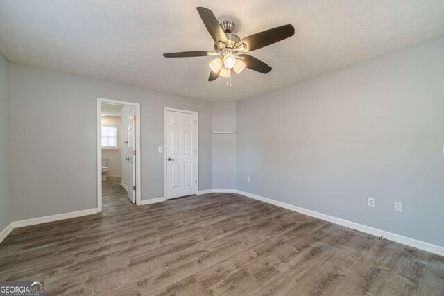 29 Monte Ln, Jefferson, GA 30549 - unfurnished bedroom featuring wood finished floors, ensuite bathroom, and a ceiling fan