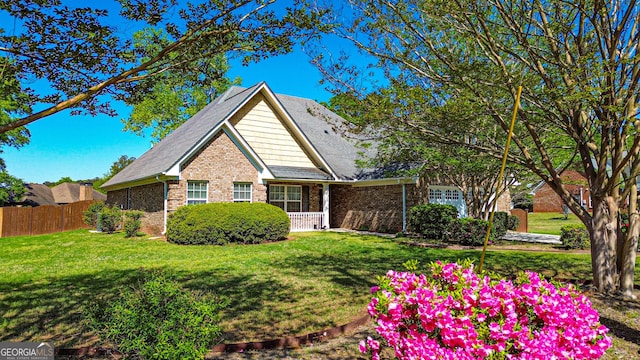 view of front of property featuring a front yard, fence, and brick siding