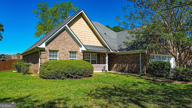 view of front of property with a front yard, fence, and brick siding