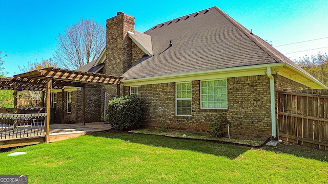 rear view of house featuring a chimney, a pergola, brick siding, a yard, and fence