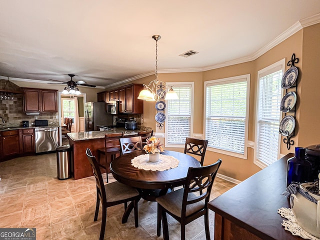 dining space featuring visible vents, ceiling fan with notable chandelier, and ornamental molding