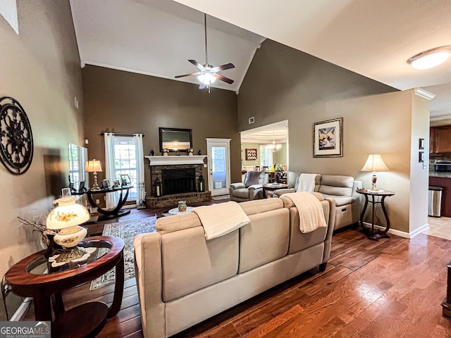 living room with a brick fireplace, a ceiling fan, high vaulted ceiling, and wood finished floors
