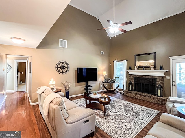 living room with visible vents, baseboards, a brick fireplace, a ceiling fan, and wood finished floors