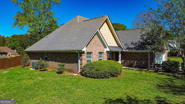 view of side of home featuring brick siding, fence, a lawn, and central air condition unit