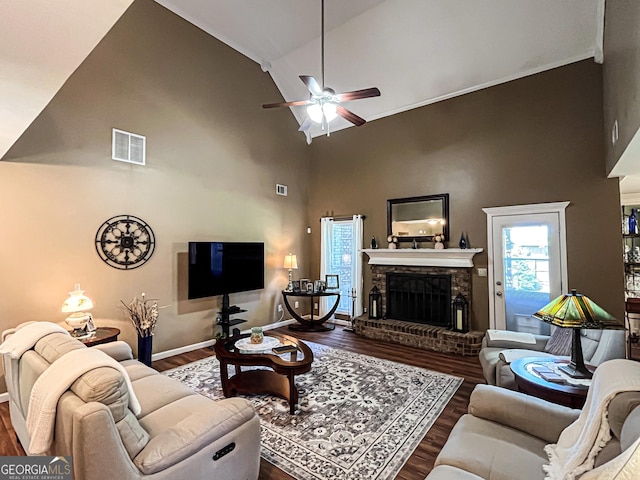 living area featuring visible vents, a fireplace with raised hearth, ceiling fan, wood finished floors, and high vaulted ceiling