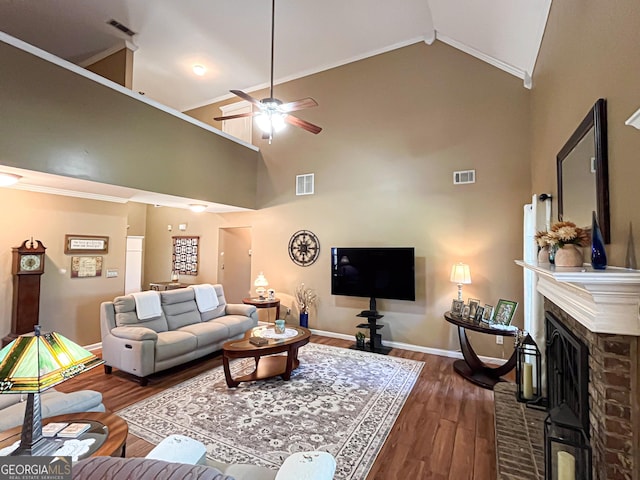 living room with a fireplace, visible vents, baseboards, and wood finished floors