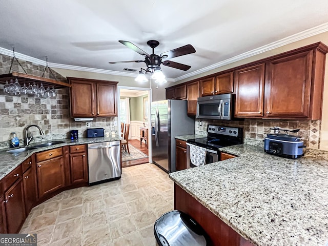 kitchen featuring a sink, ceiling fan, stone finish floor, light stone countertops, and stainless steel appliances