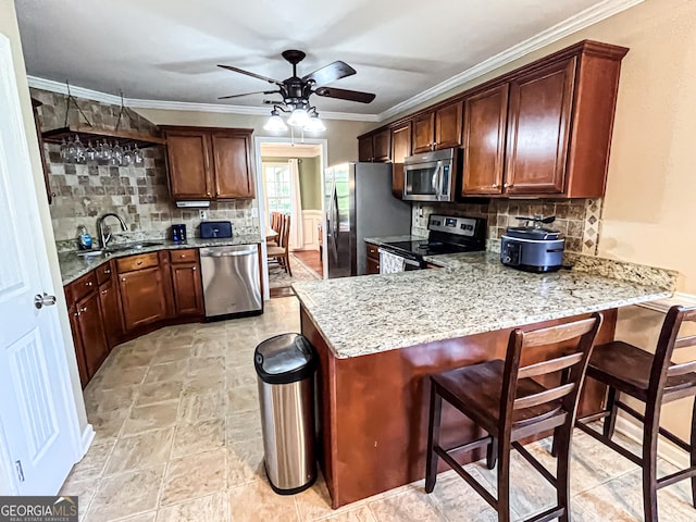 kitchen featuring a sink, backsplash, a peninsula, and stainless steel appliances