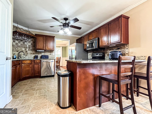 kitchen featuring decorative backsplash, light stone countertops, a peninsula, and stainless steel appliances