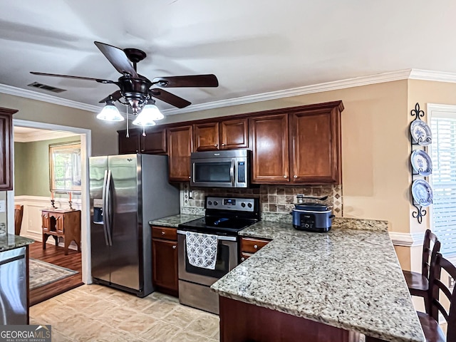 kitchen featuring visible vents, appliances with stainless steel finishes, a ceiling fan, a peninsula, and decorative backsplash