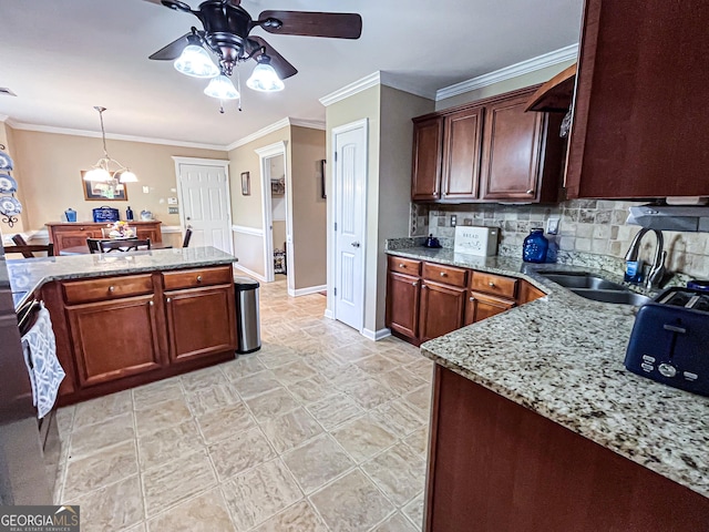 kitchen with ornamental molding, backsplash, light stone countertops, ceiling fan with notable chandelier, and a sink