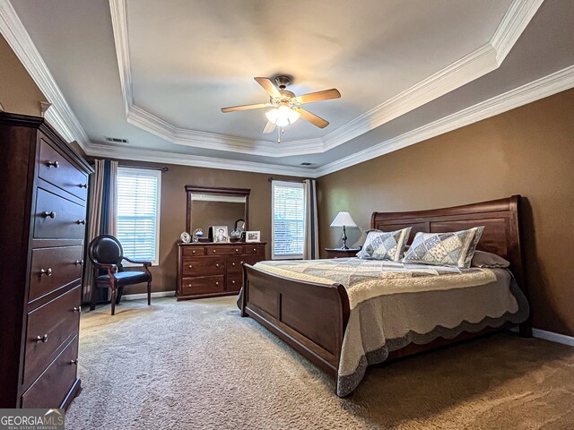 bedroom featuring a raised ceiling, light carpet, crown molding, and multiple windows