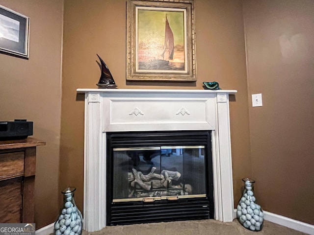 room details featuring baseboards and a glass covered fireplace