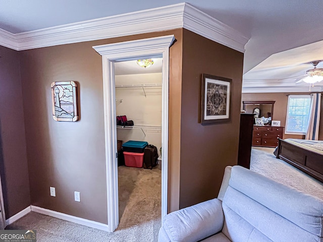 hallway with carpet flooring, baseboards, and crown molding