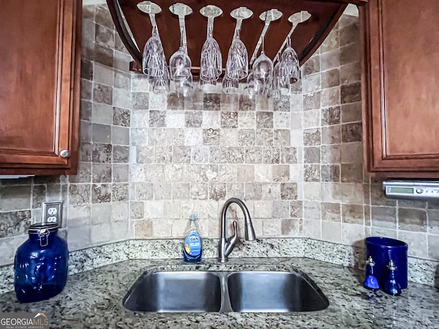 kitchen with a sink, brown cabinetry, and tasteful backsplash