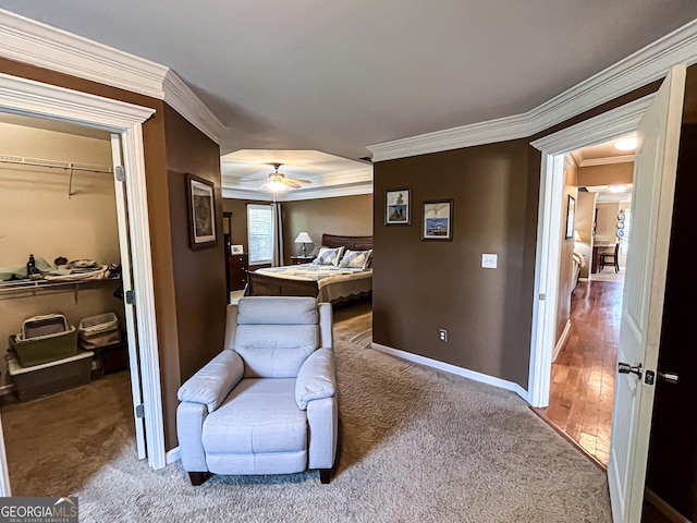 carpeted bedroom featuring a closet, a walk in closet, baseboards, and ornamental molding