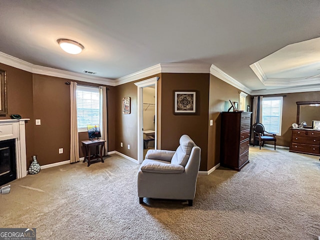 sitting room with light carpet, a healthy amount of sunlight, ornamental molding, and visible vents