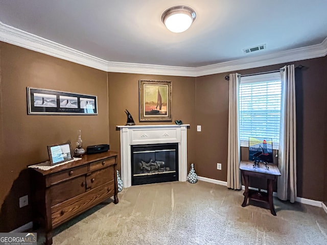 living area with visible vents, baseboards, ornamental molding, carpet floors, and a glass covered fireplace