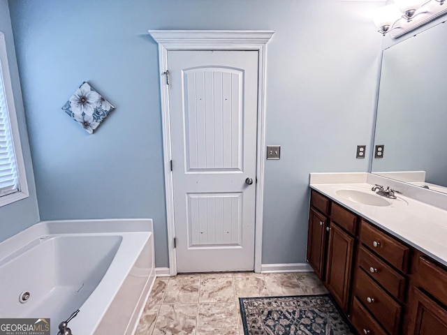 full bathroom featuring baseboards, vanity, and a garden tub