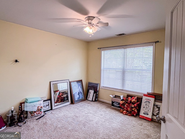 recreation room featuring visible vents, a ceiling fan, and carpet